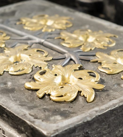 Stylish golden flower and grey branches molded in high precision cast in traditional production plant workshop extreme close view